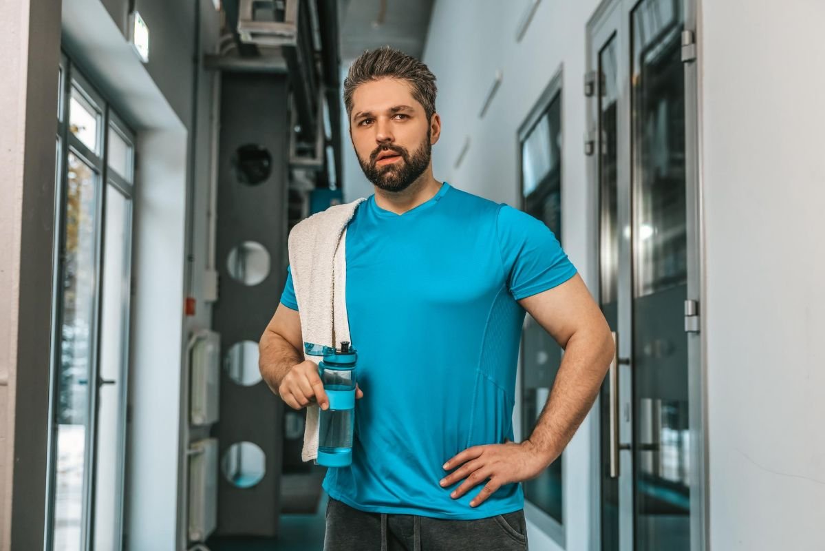 homem com camisa de tecido dry fit se hidratando