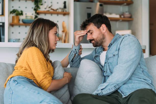 Worried couple talking together in the living room at home. Shot of young wife expressing empathy and compassion to her sad frustrated husband. lovers stock pictures, royalty-free photos & images