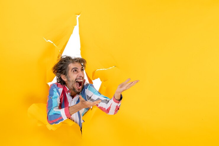 a man with a funny expression coming out of a ripped background