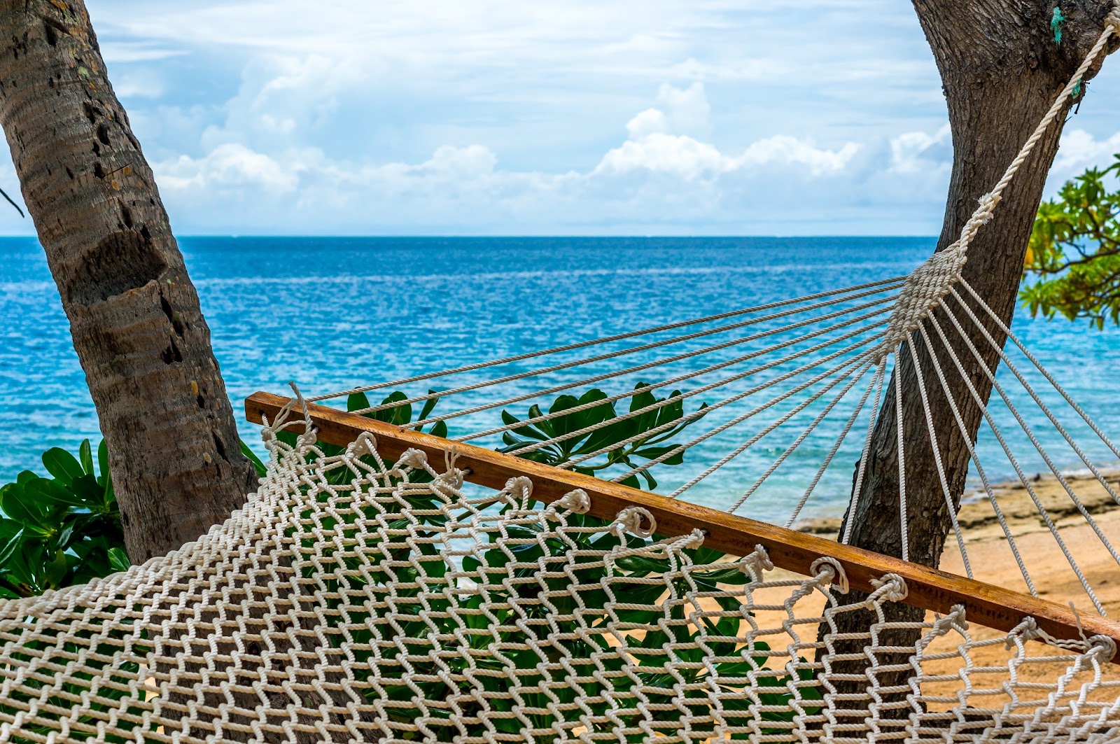 A hammock over looking the beautiful waters and a luxurious beach in Fiji.