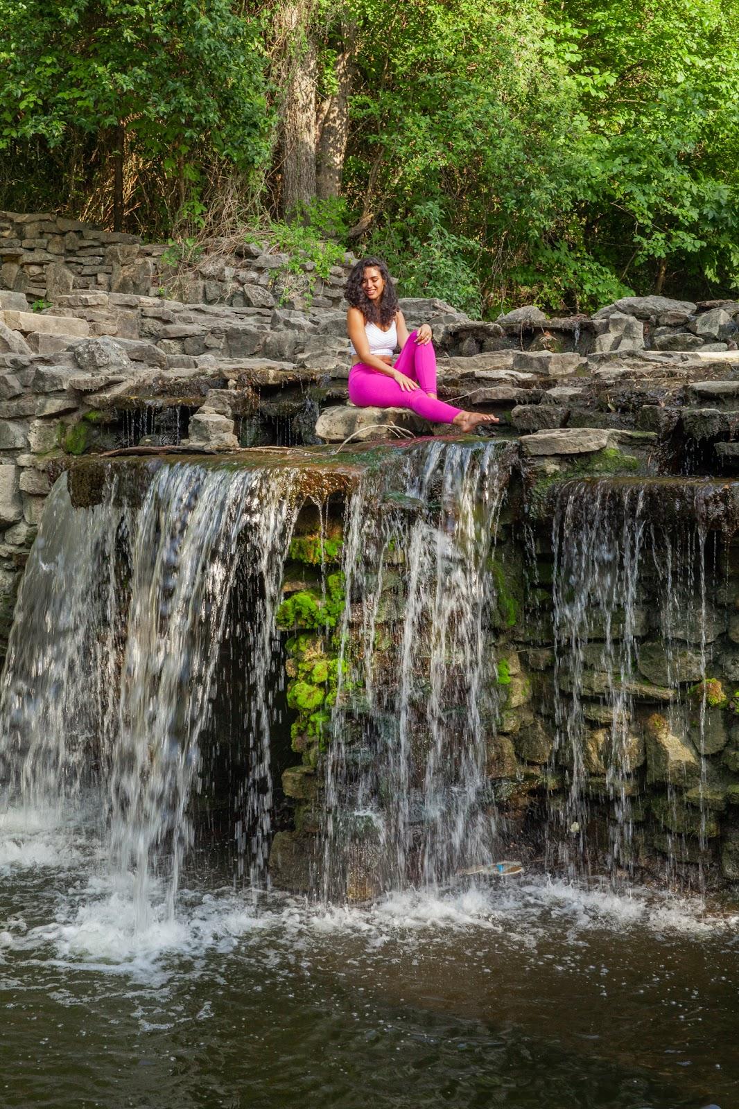 me sitting on a rock ledge with a waterfall