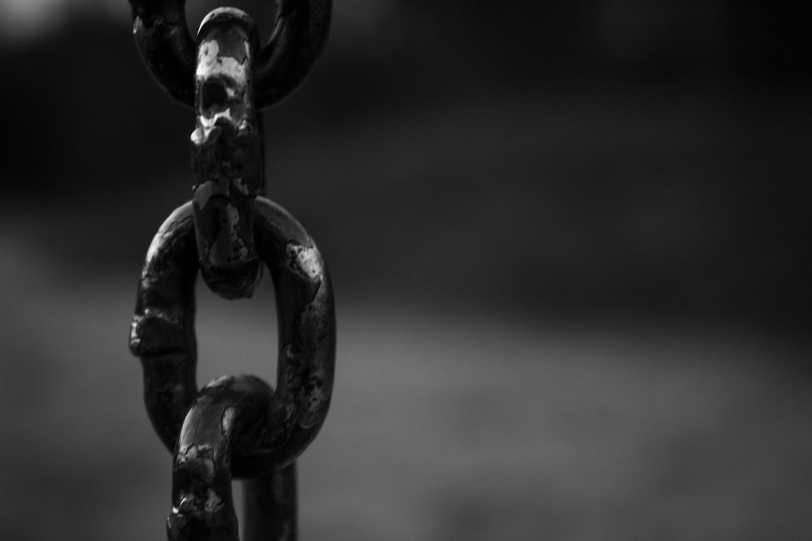 Black iron chain against a gray background