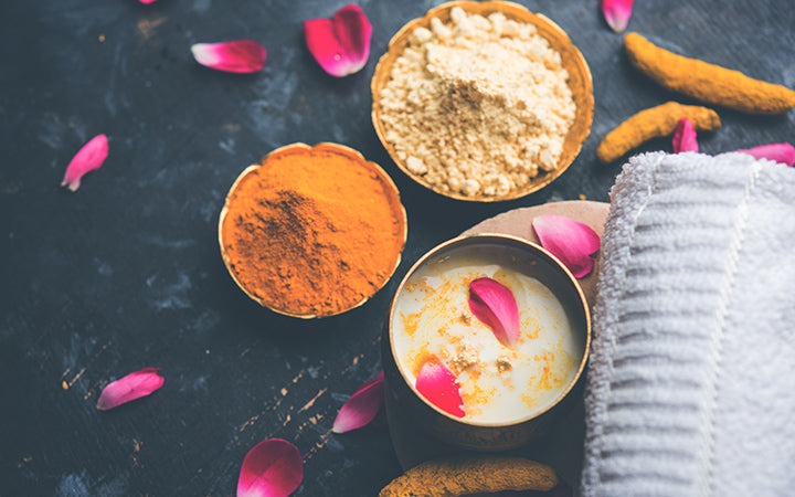 Ayurvedic face mask using Gram flourbesan, Haldi & Milk ubtan placed in brass bowls