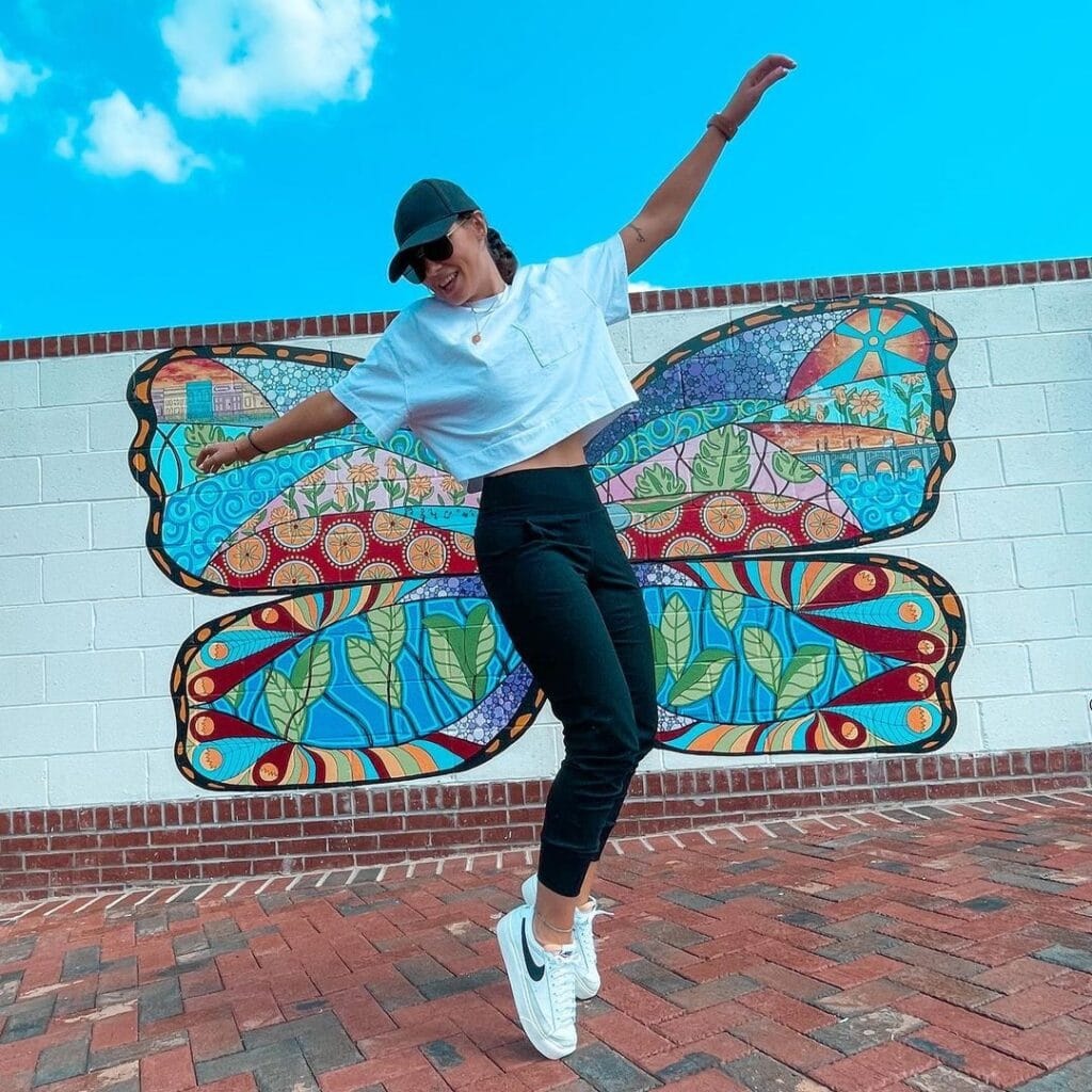 Picture of a lady rocking crop top and egging while aiming for a high jump