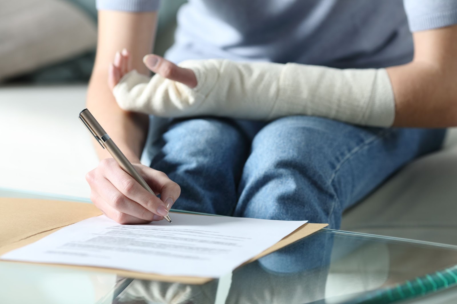 A person fills out insurance documets with a bandaged left arm.