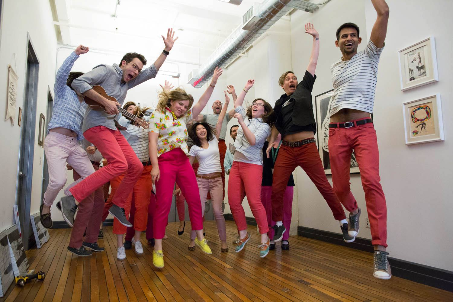 Etsy employees jumping while wearing pink pants