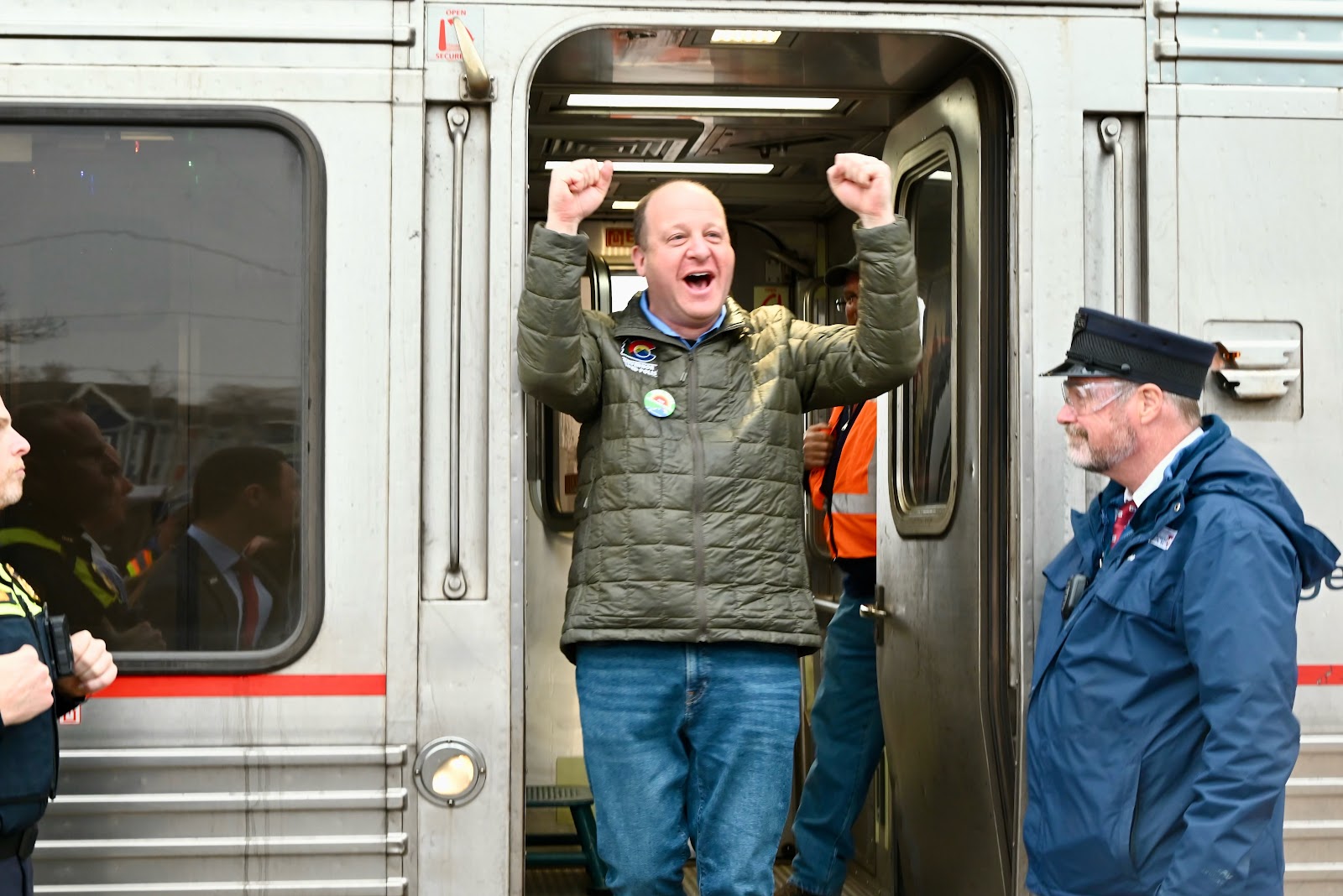 Governor Polis celebrates as he disembarks the train in Longmont.