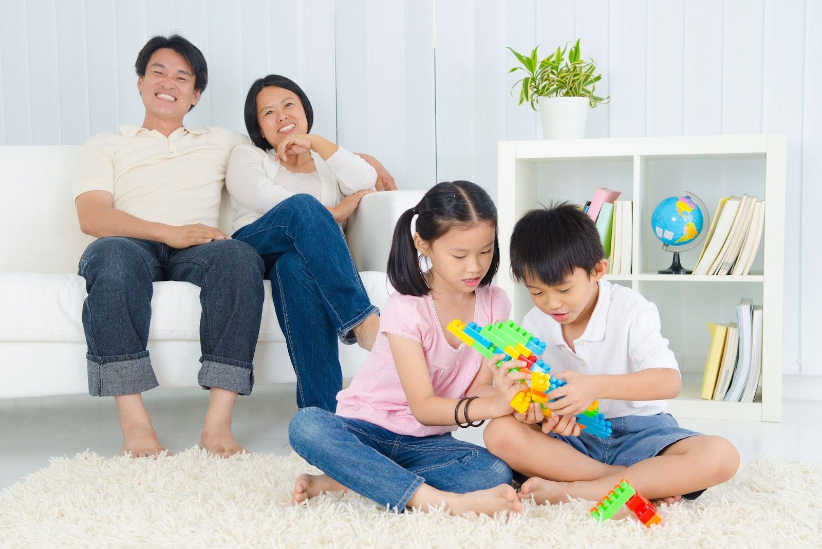 famille-minimaliste-organisation : famille minimaliste : les parents se reposent sur le canapé pendant que les enfants jouent