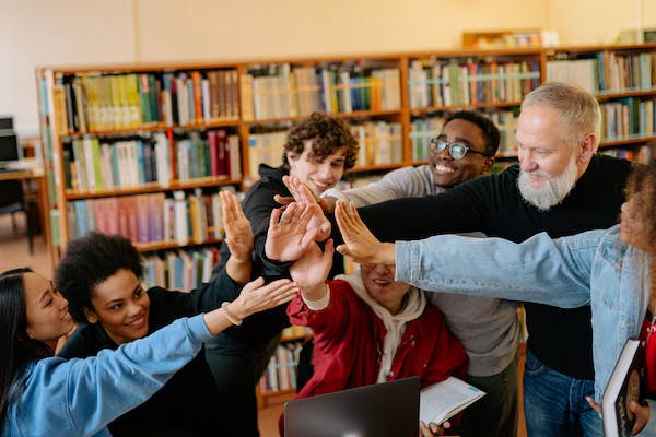 Group of students and teacher giving a high-five.