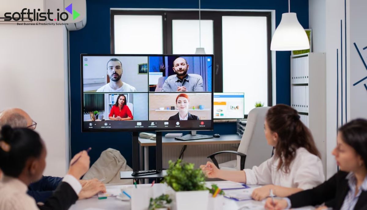 A group of people having a meeting in a conference room, utilizing a VoIP phone system.