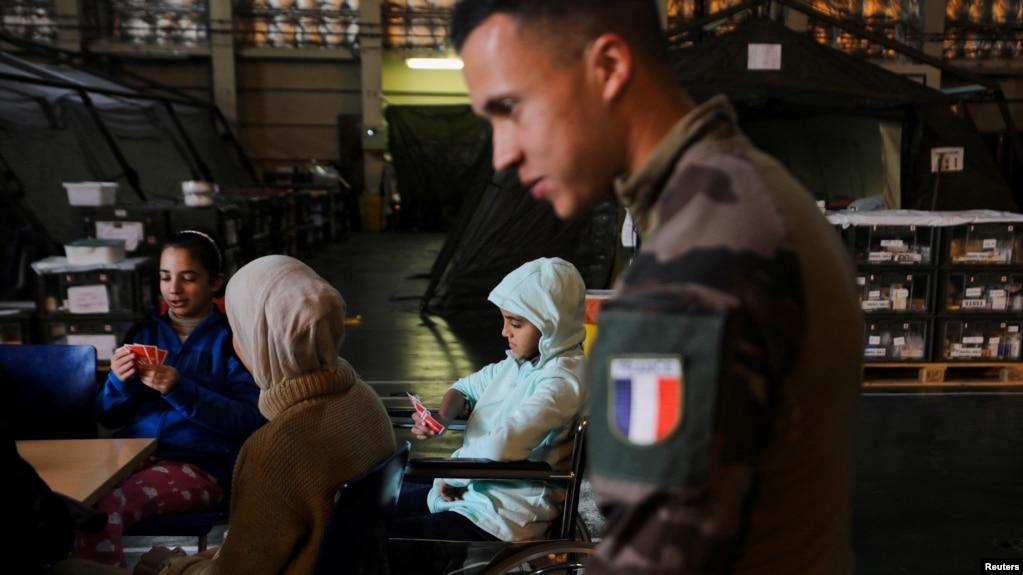 Một binh sĩ hải quân Pháp và một bé gái Palestine bị thương trên tàu Dixmude.