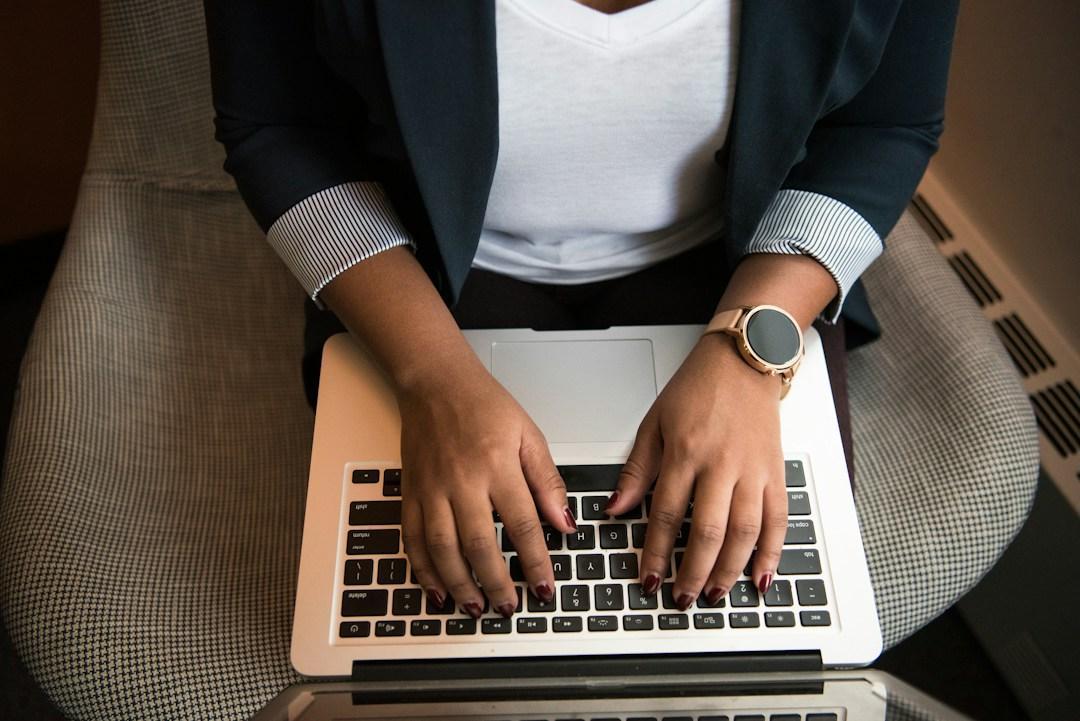 Businesswoman implementing telecom expense management tools with laptop on lap