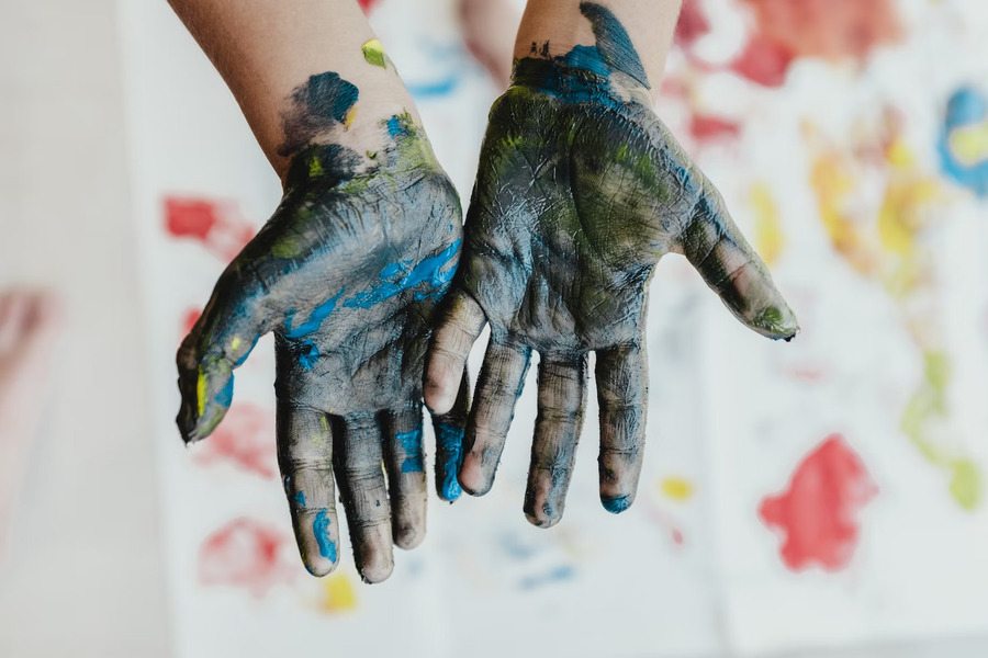 A person's hands showcasing slightly removed body paint
