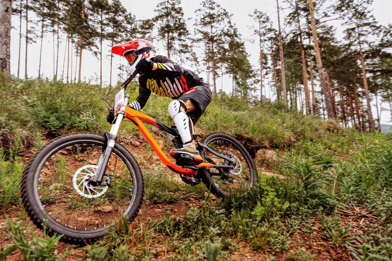 A downhill biker on a steep trail, highlighting the sturdy build of mountain bikes, crucial for how to choose a mountain bike for downhill riding
