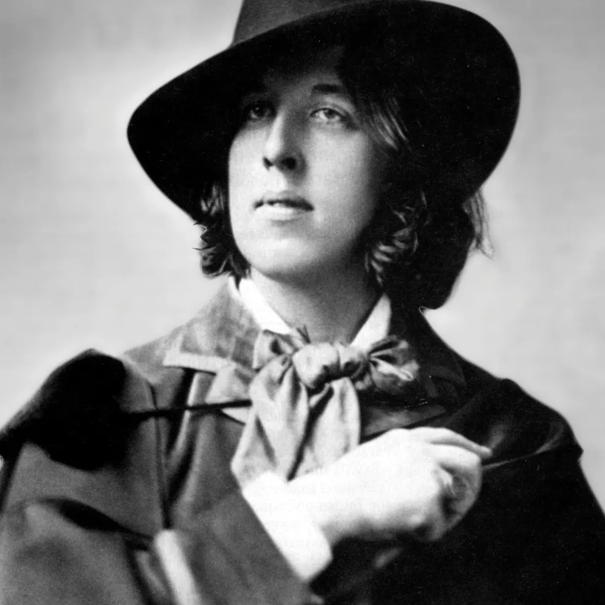  Black and white image of Oscar Wilde in a fedora and scarf.