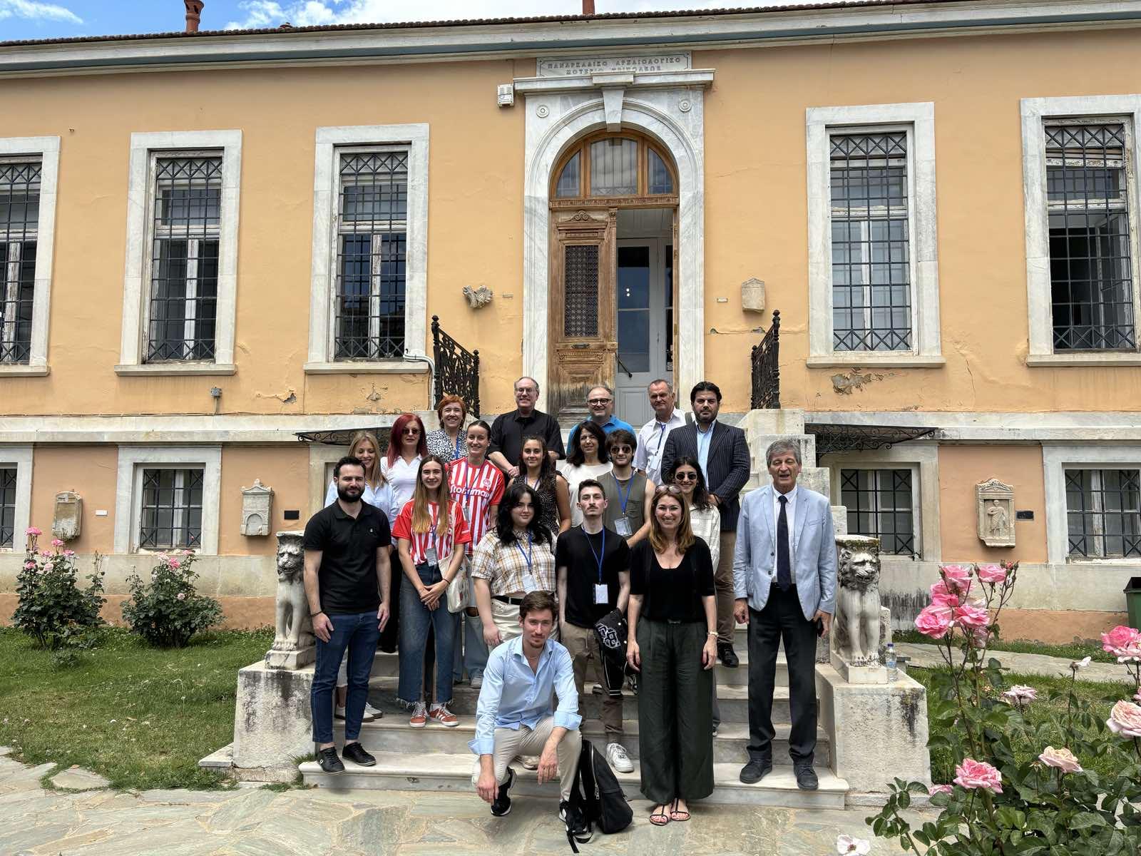 A group of people standing on steps in front of a building

Description automatically generated