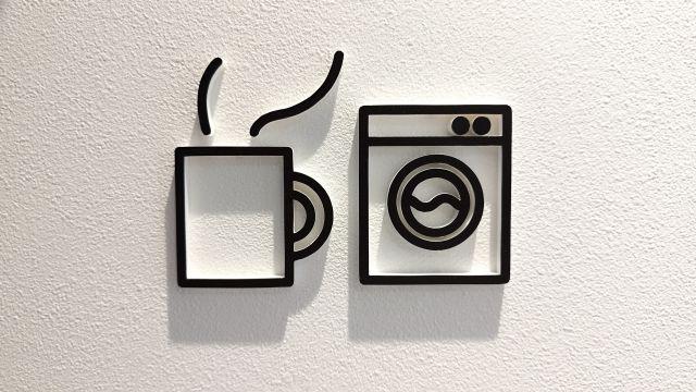コインランドリーの壁面サイン。カフェと洗濯機のサインがシンプルでかわいい印象。