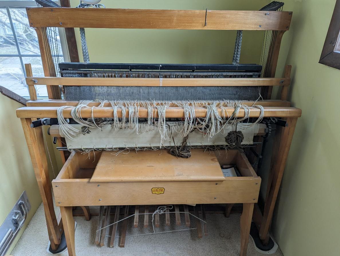 A loom with strings from it Description automatically generated
