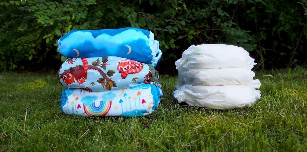 a stack of diapers sitting on top of a lush green field