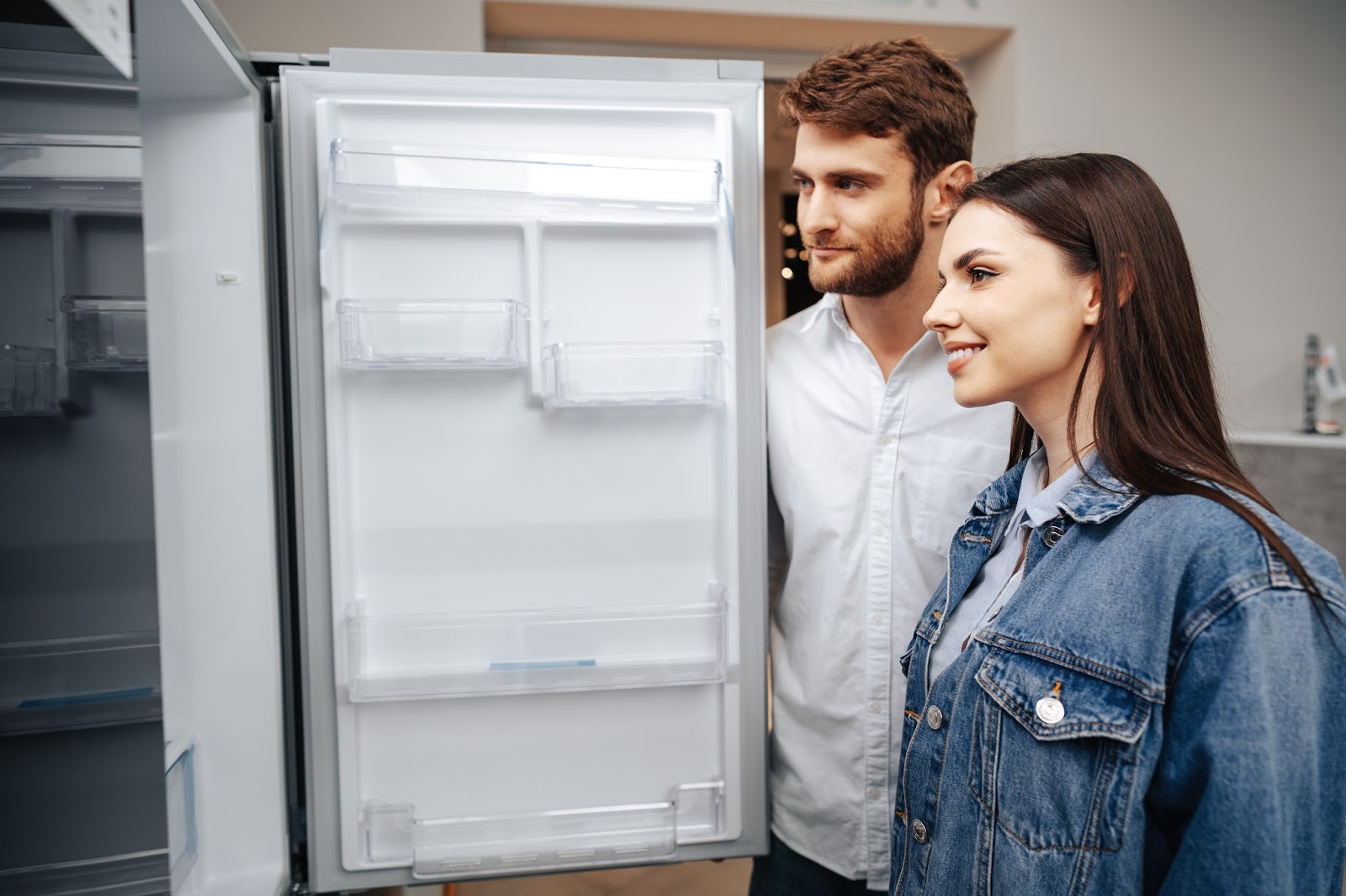 Young couple looking at their newly fixed Samsung refrigerator