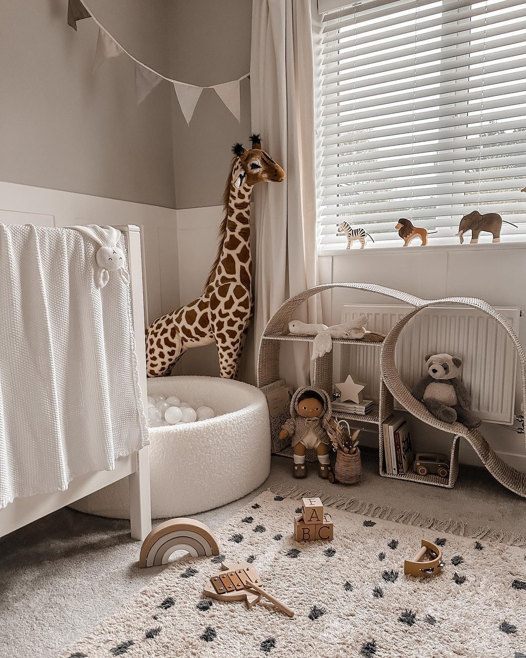 Safari themed boy's nursery with animal plush toys.
