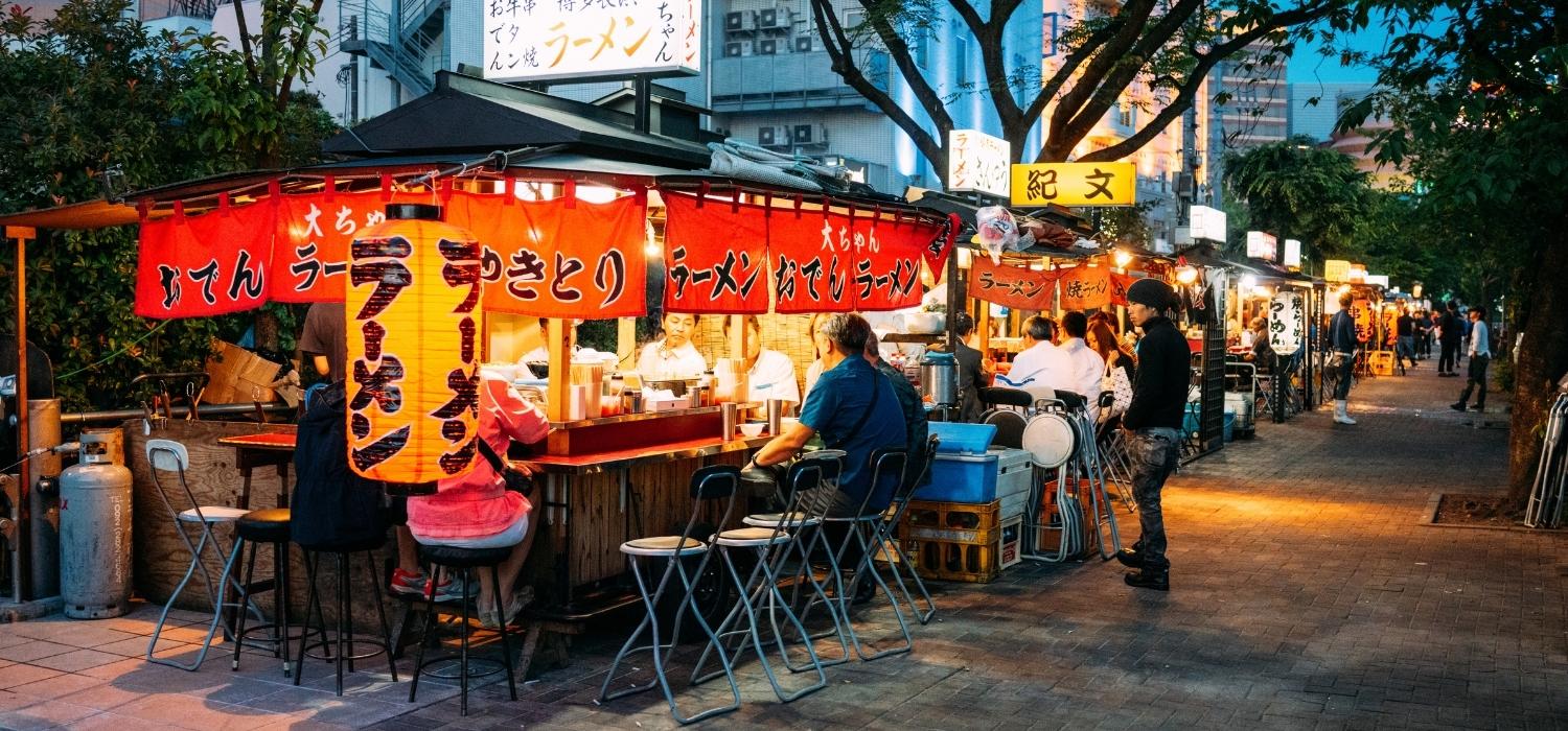 A Japanese food stand on the edge of red and black, many customers sit while looking for ChatGPT in the hotel industry.