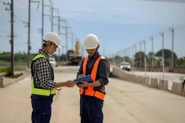 highway engineers discuss plans for construction improvement based on roadworks. soil fill, backfill compaction for sub base, base course, surveyor engineer inspector in highway construction. - the role of asphalt paving in infrastructure development stock pictures and images