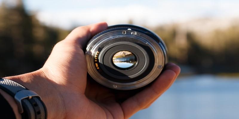 A hand holding a camera lens

Description automatically generated