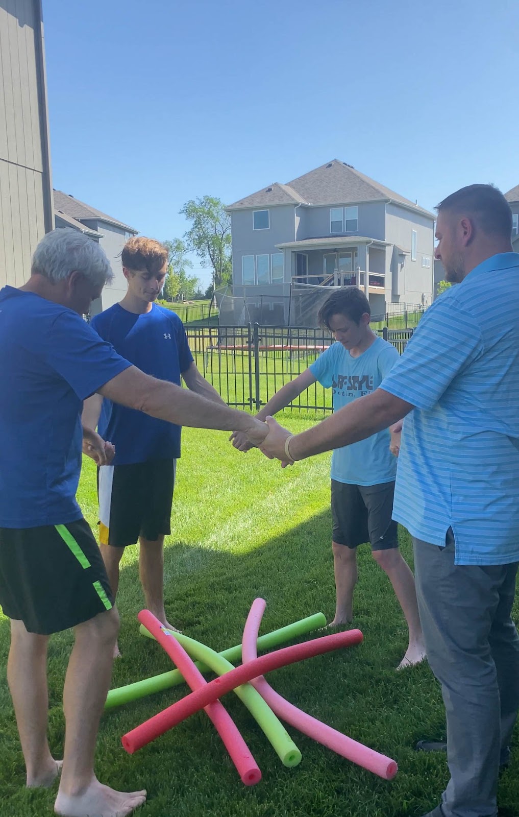 group of people standing around a bunch of pool noodles