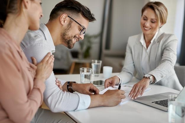 Free photo happy man and his wife having a meeting with financial advisor and signing an agreement in the office