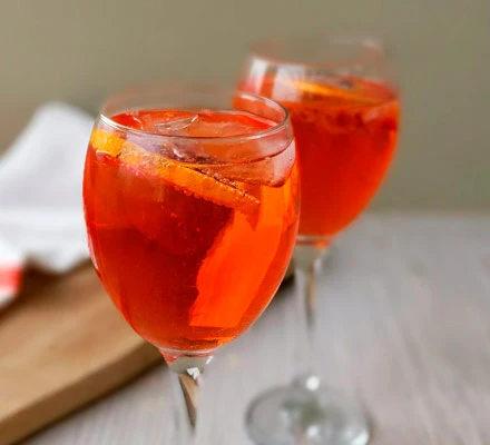 A picture of a glass of aperol spritz, perfect for a board game party.