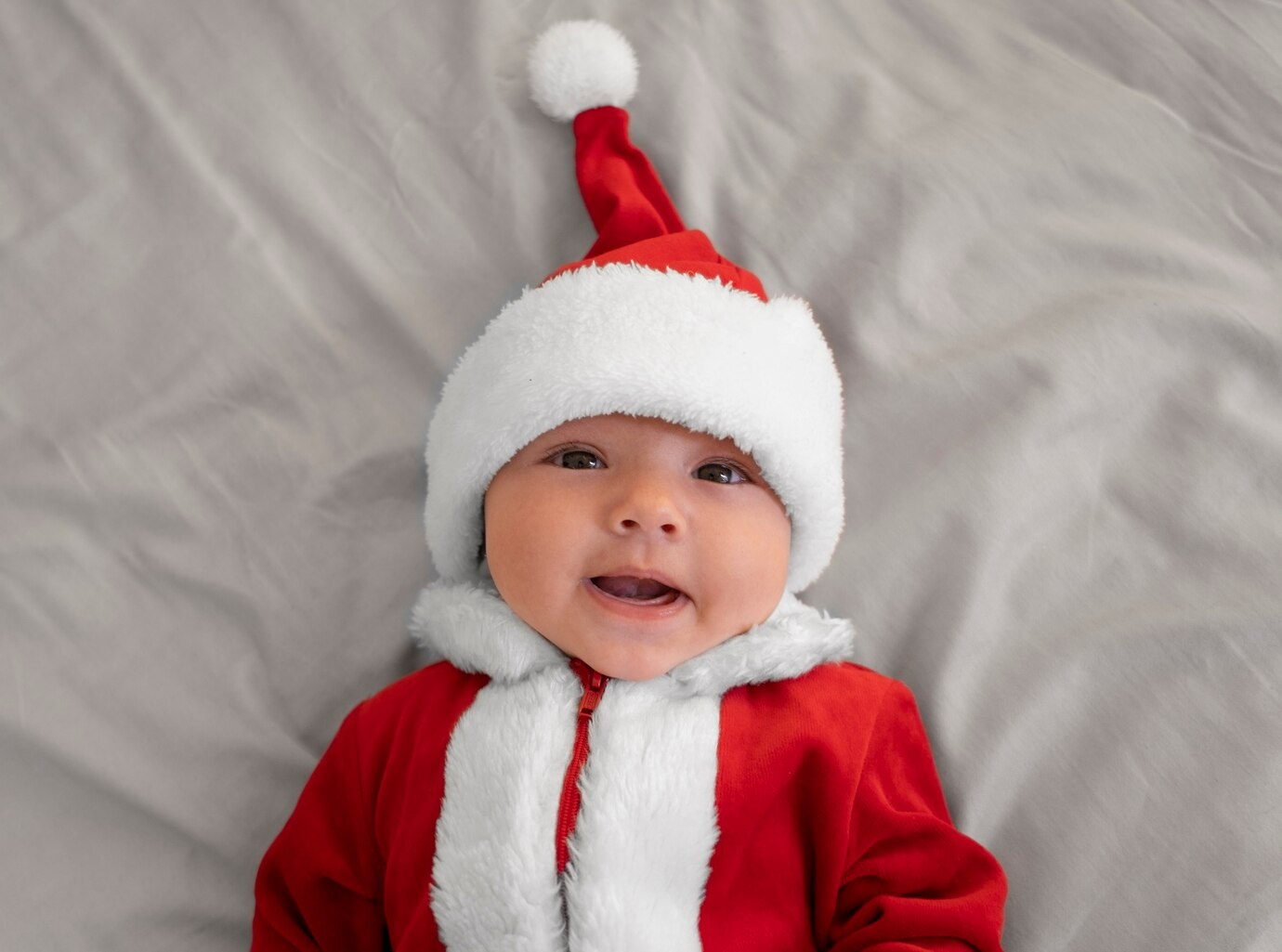 A baby dressed in Santa Claus clothing.