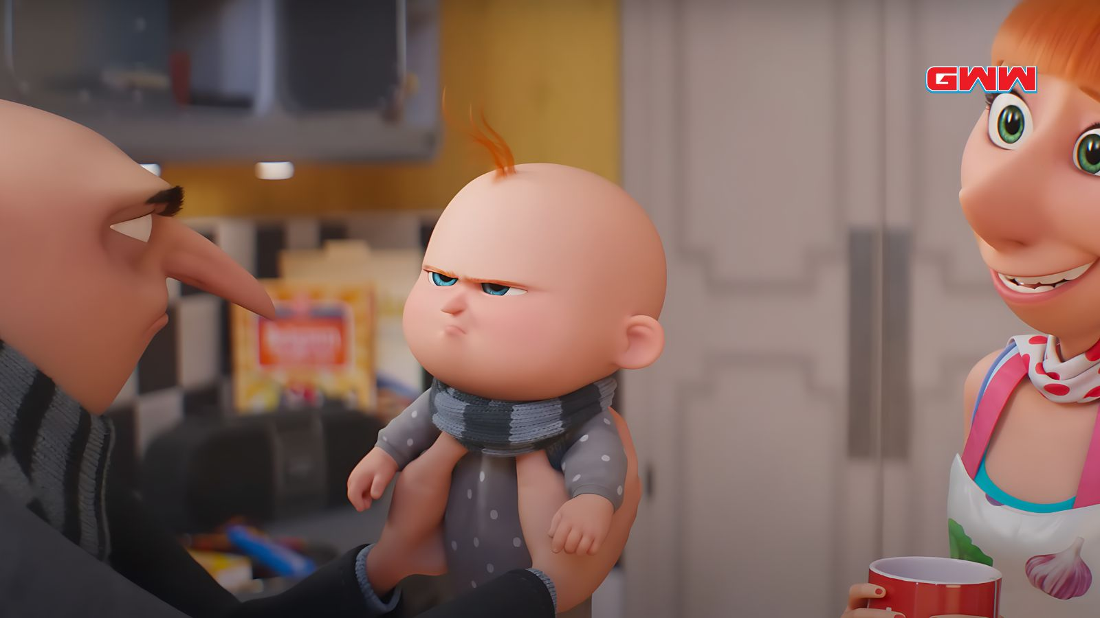 Gru is holding his baby in a kitchen with Lucy