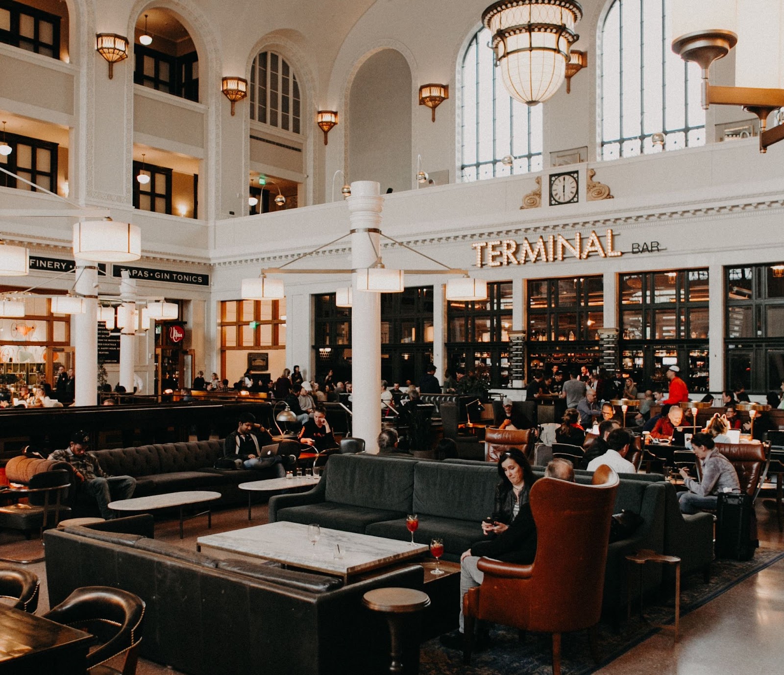 inside Denver Union Station with people sitting on couches and Terminal Bar sign