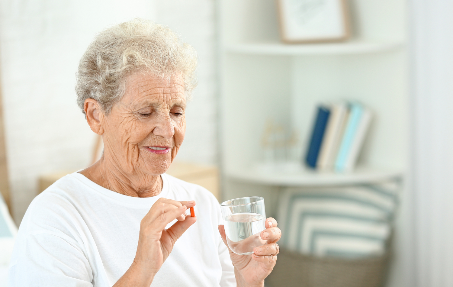 Elderly person taking a Vitamin D supplement.