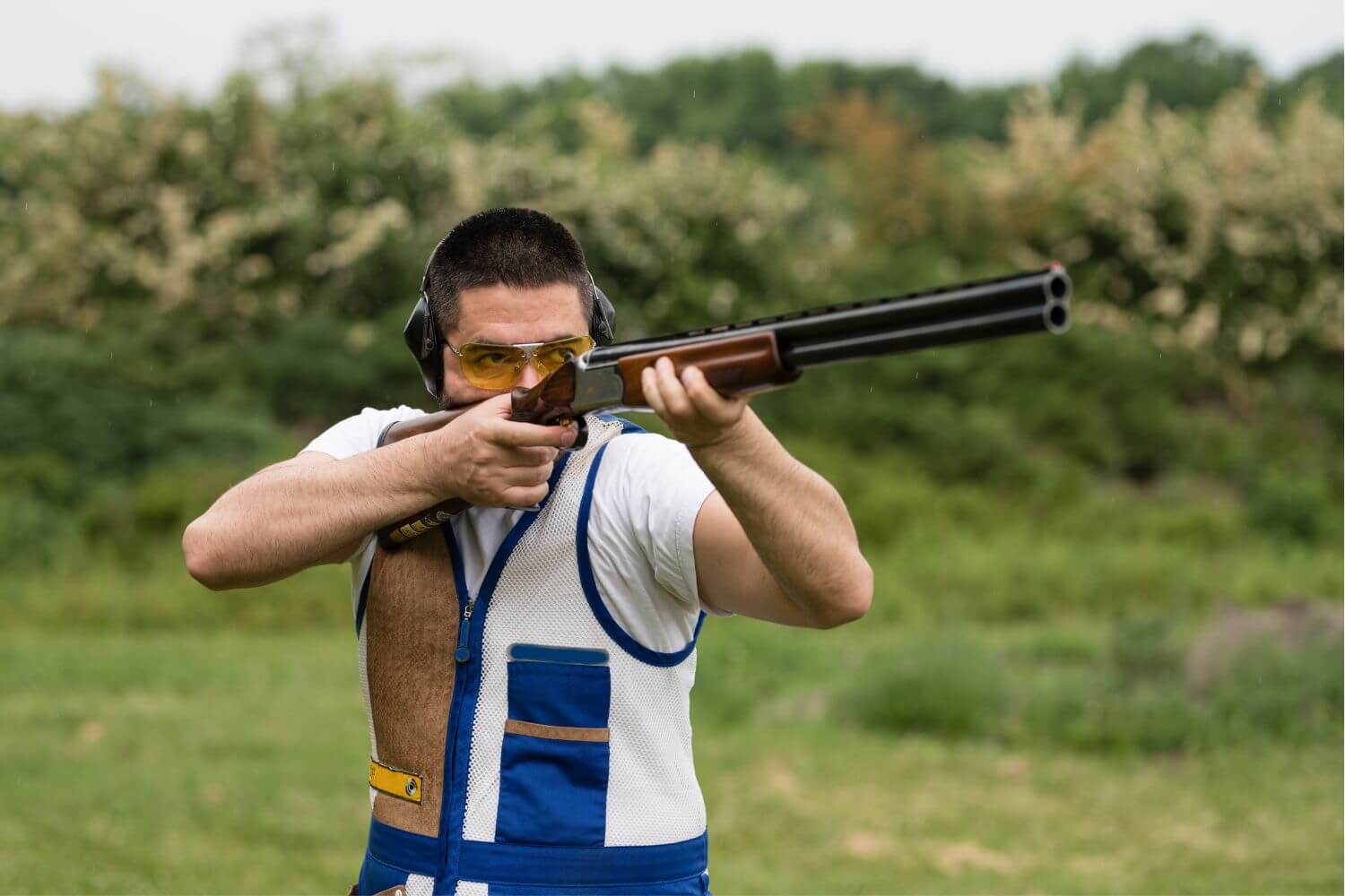 Man skeet shooting with a shotgun