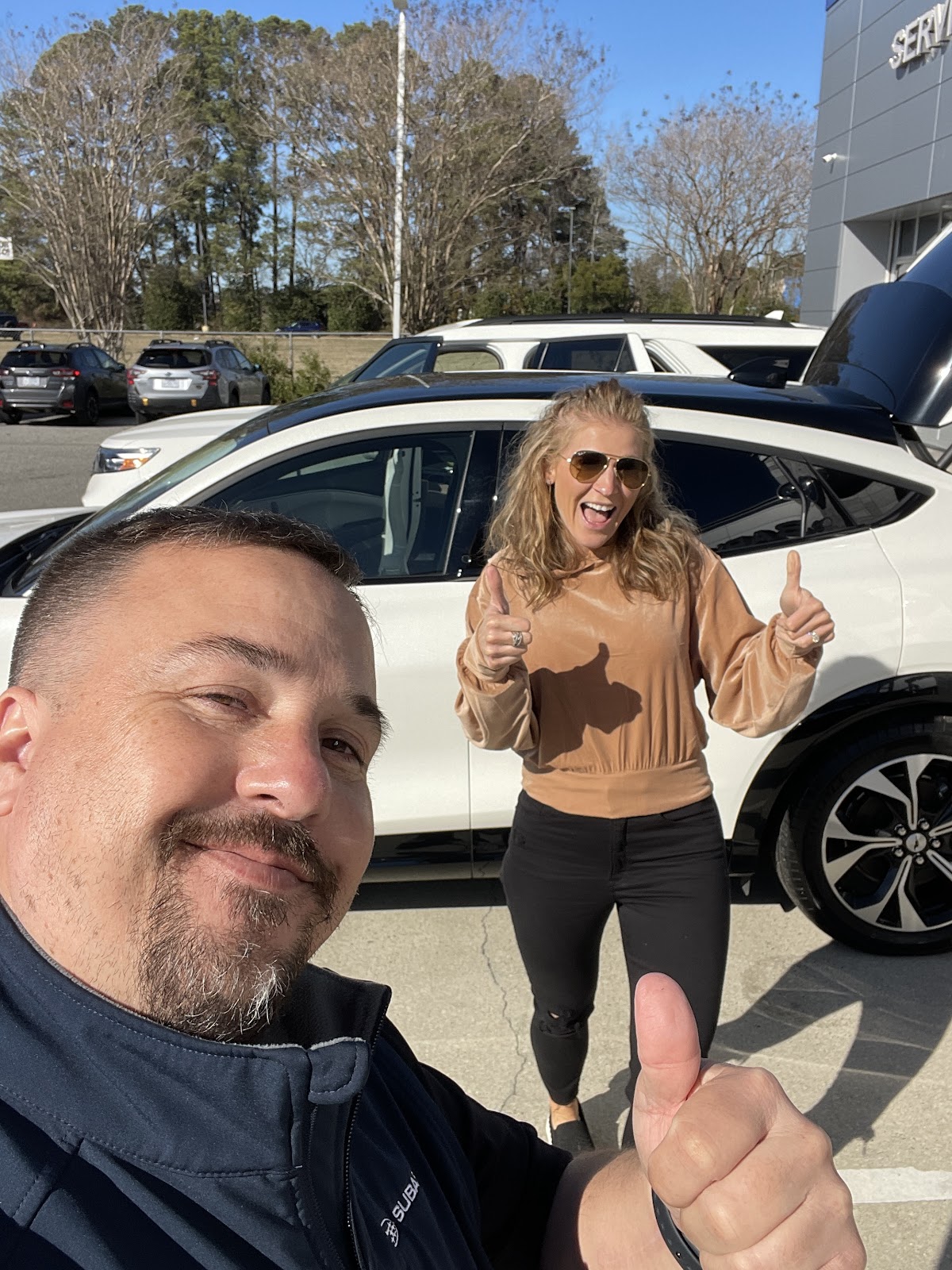 Jimmy Gerhold shaking hands with a happy customer in front of a newly purchased car at Riverside Subaru, symbolizing trusted service and customer satisfaction in New Bern, NC