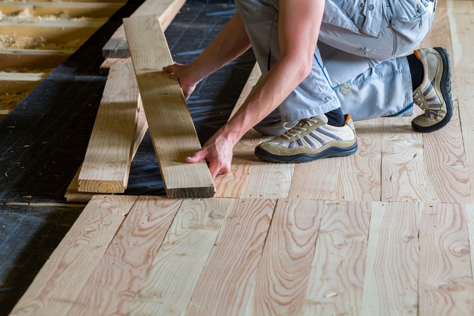  Man installing wood flooring.