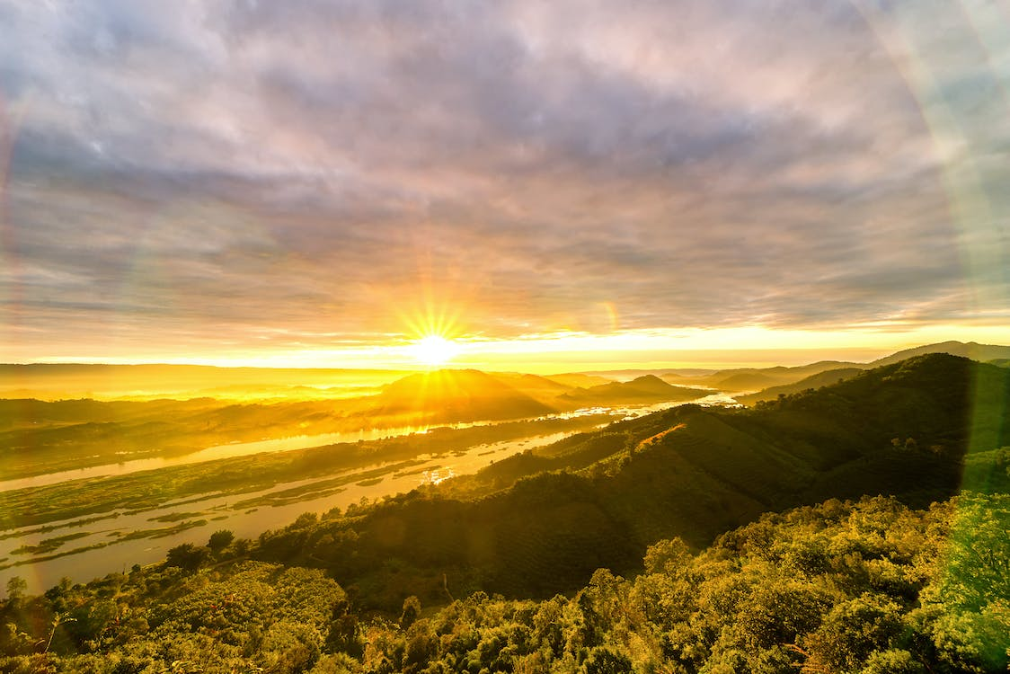 paisagem com os raios solares sendo emitido pela superfície terrestre