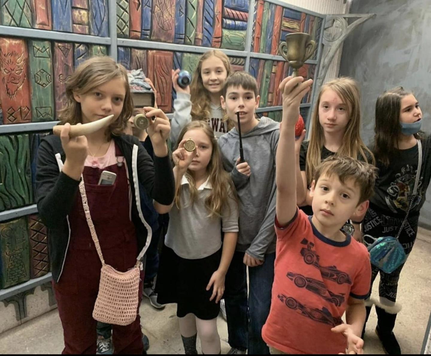 The picture shows a group of kids showing off their set of obstacles in the escape rooms for kids.

