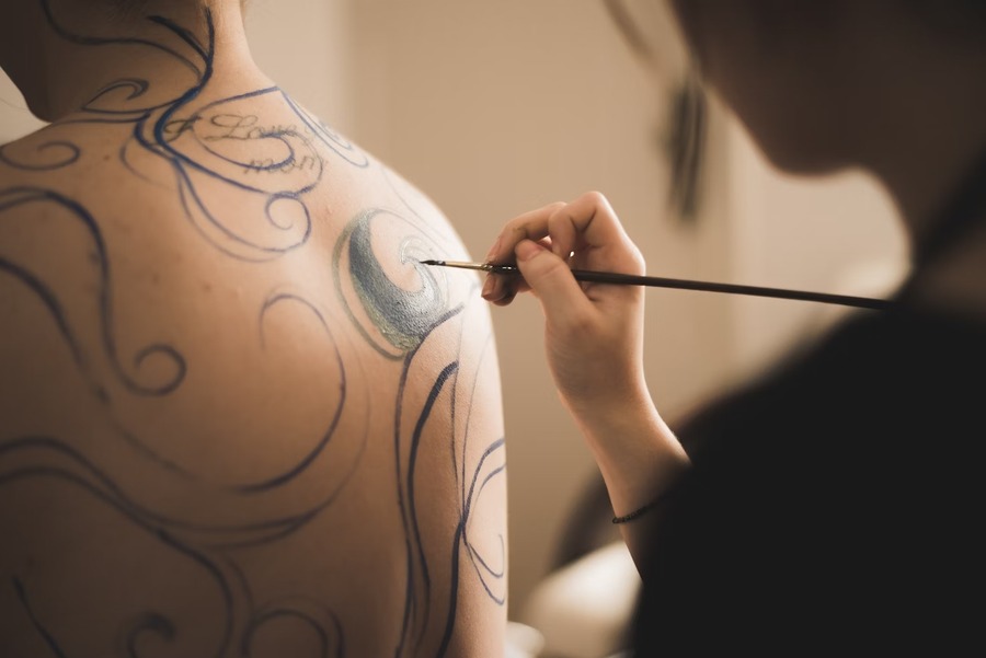 An artist painting on a person's body
