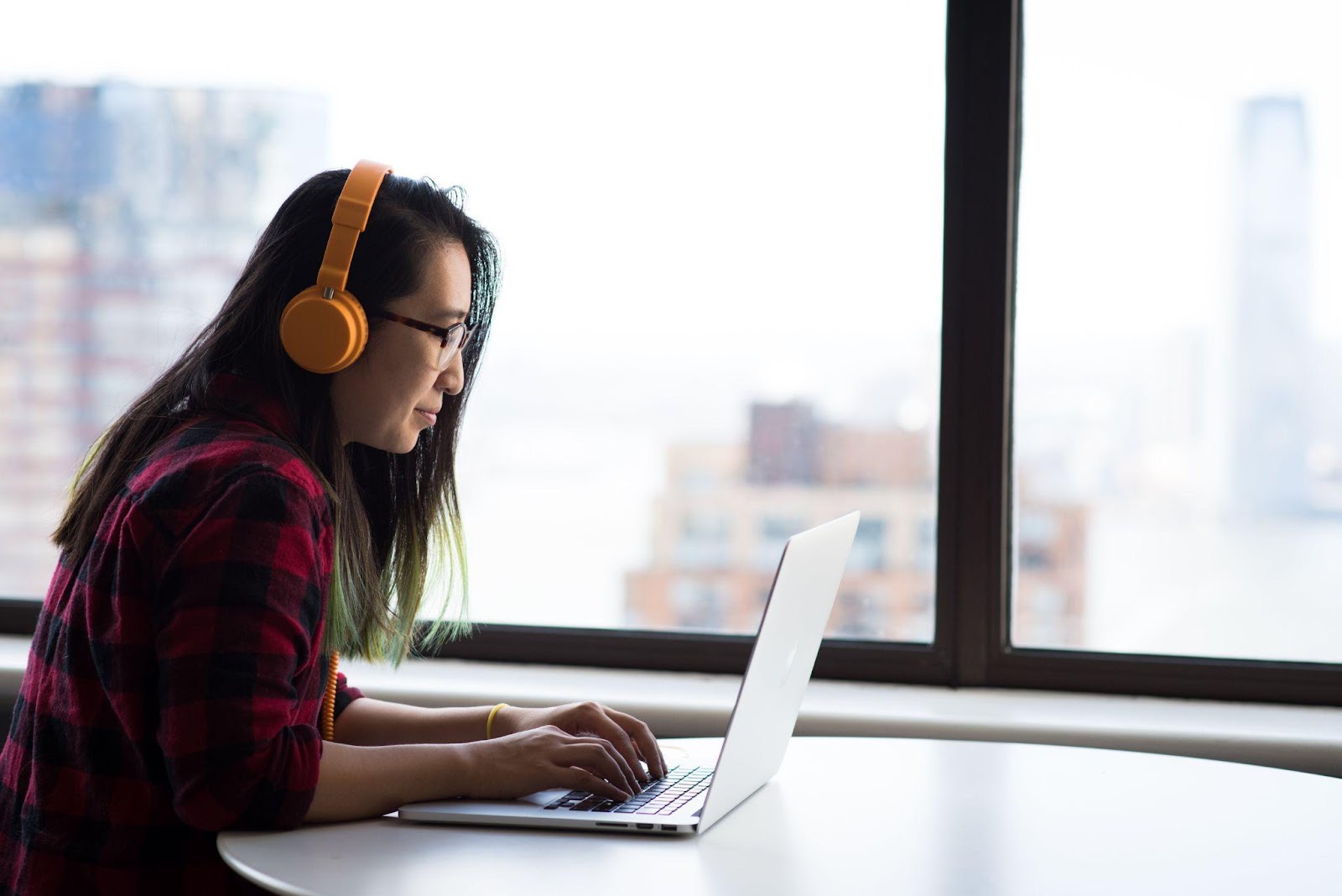 A woman slouching while working on a laptop