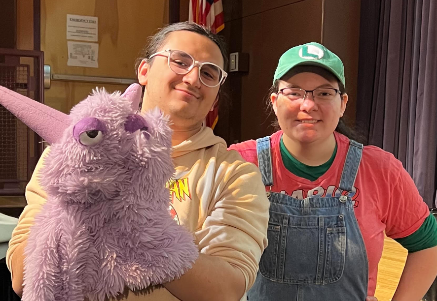 image of two students with a purple hand puppet