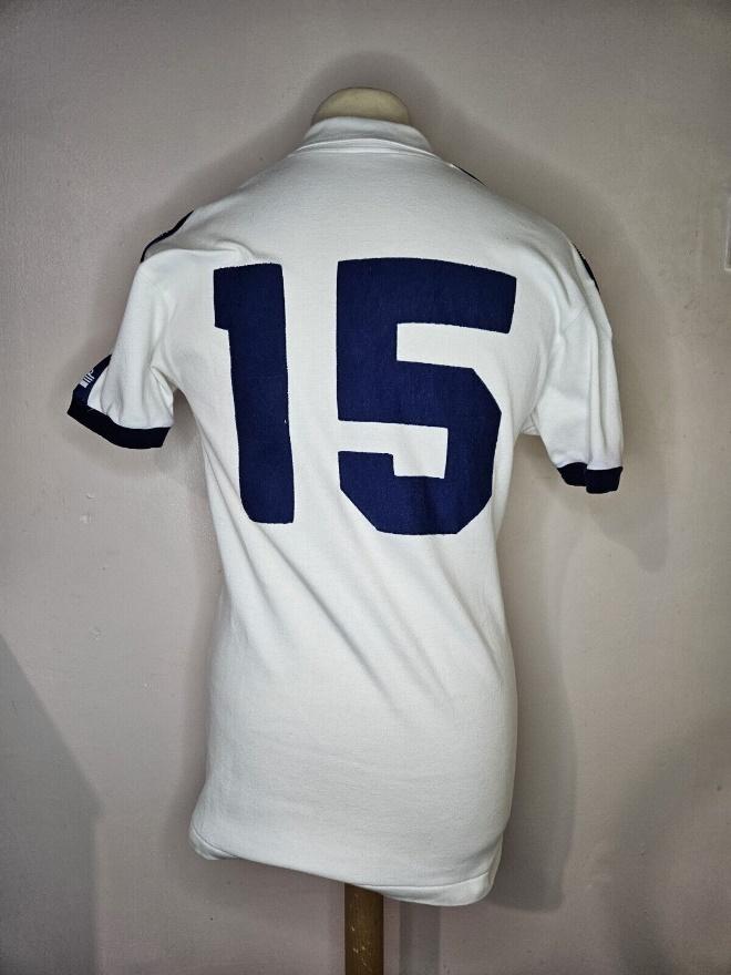 A white shirt with blue numbers on it  Description automatically generated