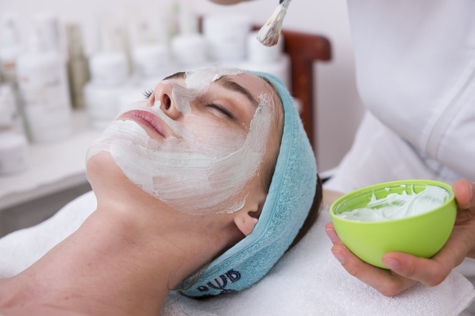 woman lying down at spa getting a face mask applied