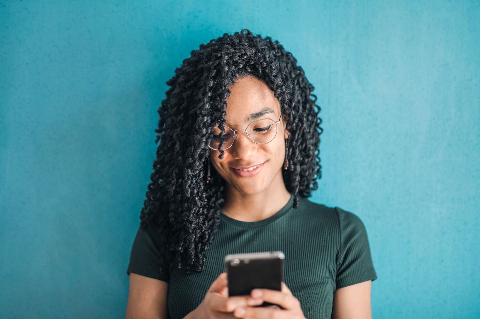 A woman using her phone to use the Threads app.