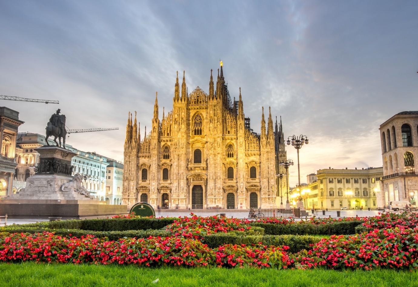 A large building with a large tower and a garden with Milan Cathedral in the background

Description automatically generated with medium confidence