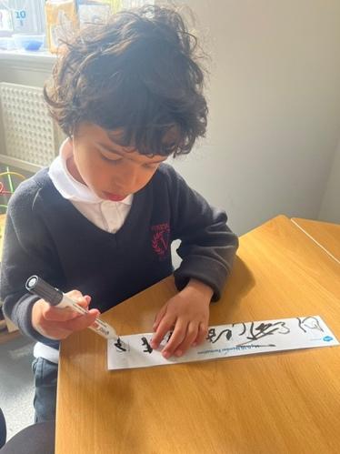 A child writing on a piece of paper

Description automatically generated