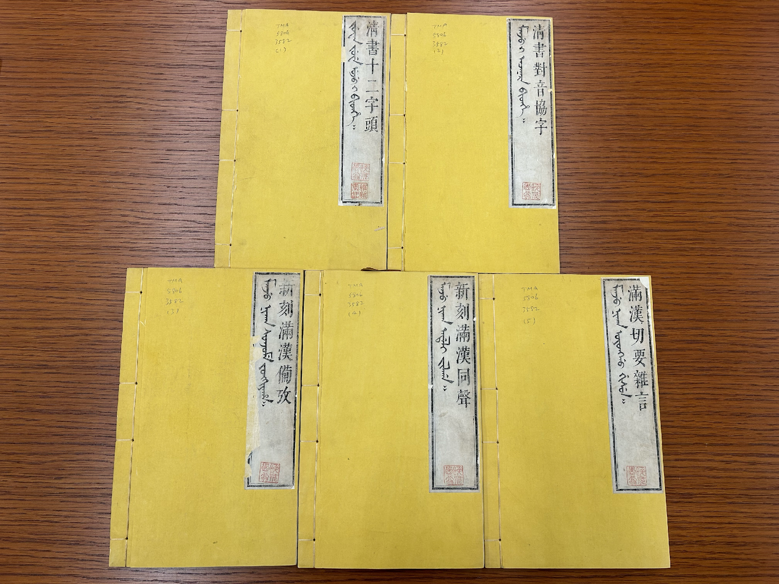 A group of yellow folders on a wood surface<br><br>Description automatically generated