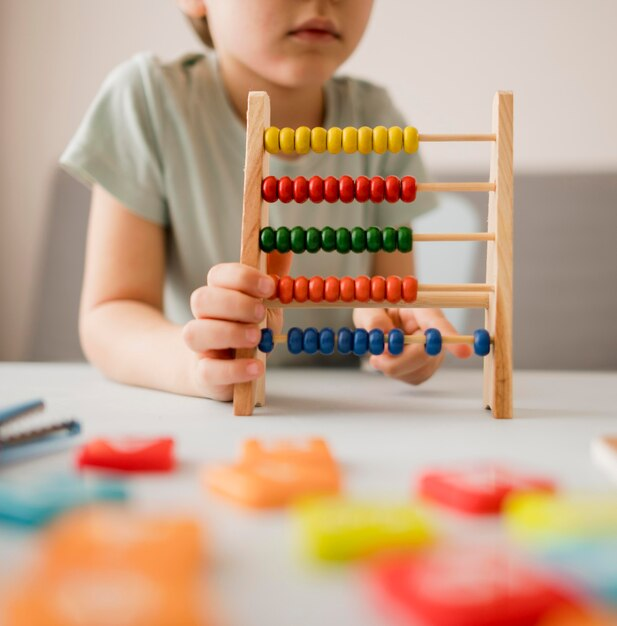 Child at home learning maths with an abacus, fostering special needs education.